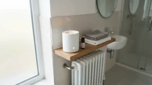 White ceramic wax warmer placed on a modern en-suite radiator shelf, highlighting fresh scent wax melts for bathroom use.